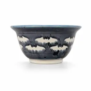 Blue and charcoal pottery bowl on a white background