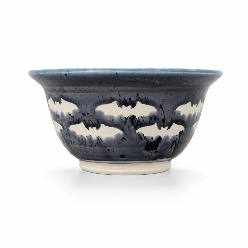 Blue and charcoal pottery bowl on a white background